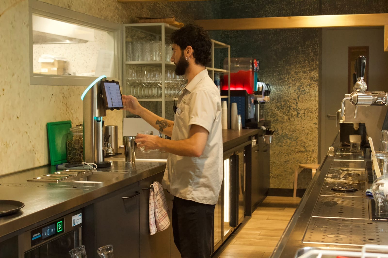 João achter de bar, hij bedient het scherm van de tap