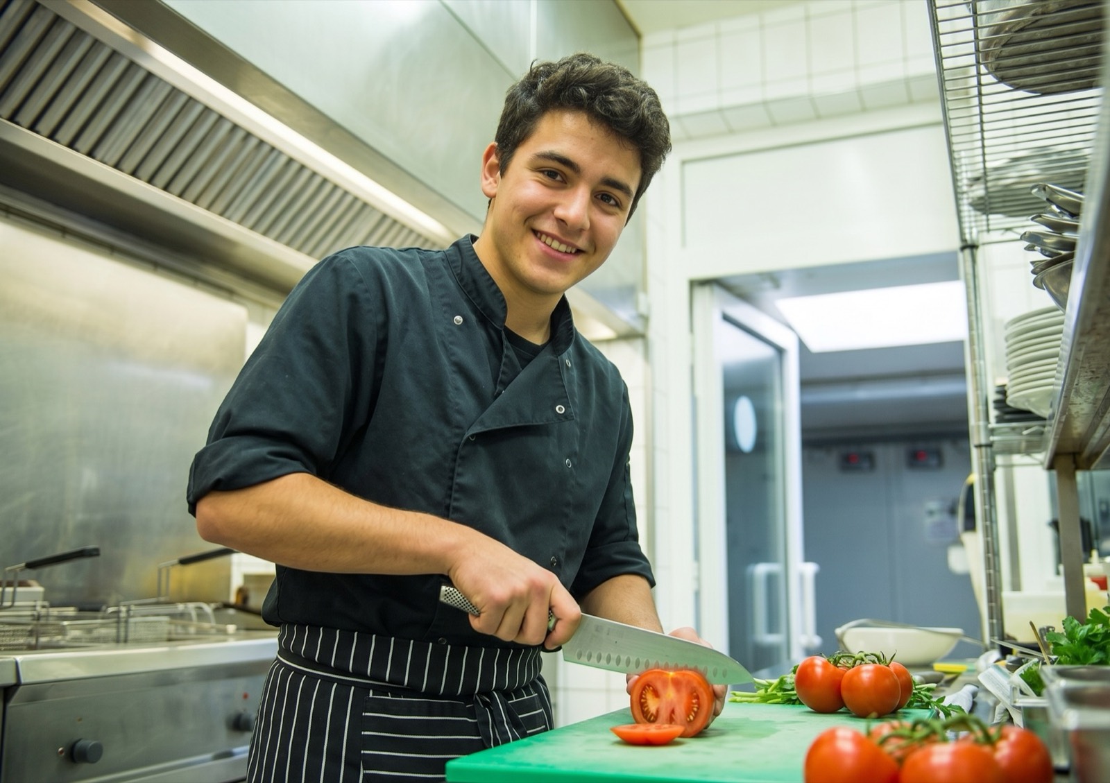 Jonge kok bereidt het werk voor in de keuken